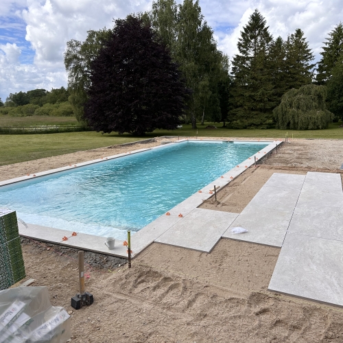 nedgravet pool og flisebelægning